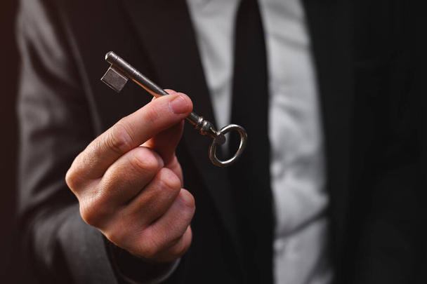 Businessman holding vintage door key, selective focus - Фото, изображение