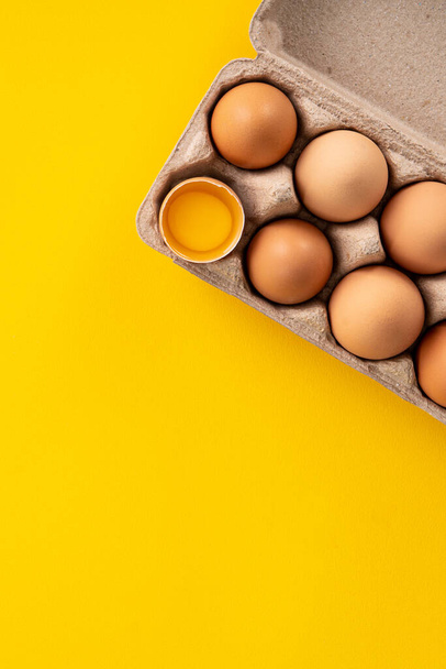 Top view of fresh brown chicken eggs isolated on yellow table background - Фото, зображення