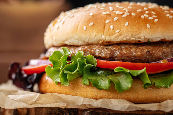 Fresh appetizing burger on wooden background - Photo, image