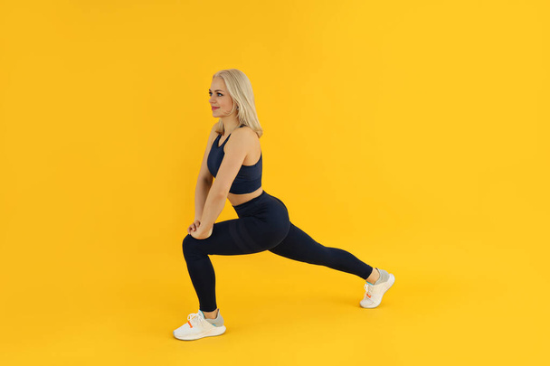 Concept of healthy lifestyle with sporty woman on yellow background - Photo, Image