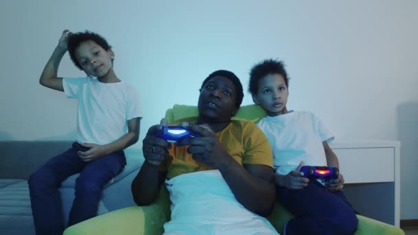 Jedyny ojciec bawiący się z synami używając joysticka - Materiał filmowy, wideo