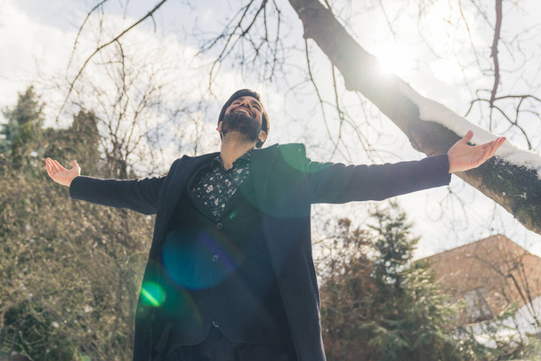 atraente barbudo latino-americano homem olhando para o céu feliz com braços estendidos ao ar livre médio tiro conceito de bem-estar  - Foto, Imagem
