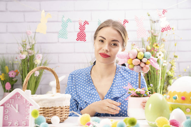 Csinos fiatal nők húsvéti dekorációt készítenek. Húsvéti háttér. Tavaszi virágcsokrok. Húsvéti tojás kosárban. - Fotó, kép