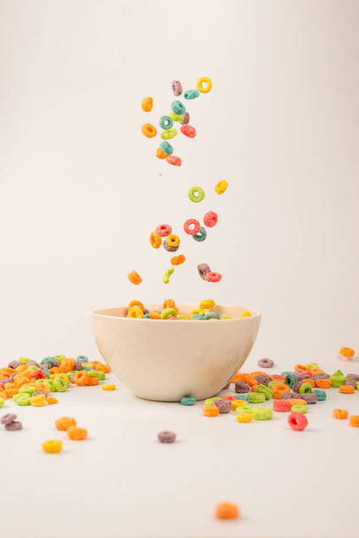 Colorful cereal box for morning breakfast. Corn flakes falling to the white bowl. Motion. Copyspace. - Photo, Image