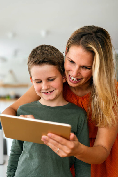 Portrait of mother and child using digital tablet for e-learning. Education home school digital device kid concept. - Foto, Imagen