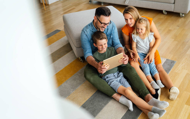 Digital device technology family online education concept. Happy young family with digital devices at home. - Photo, Image