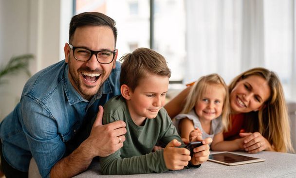 Digital device technology family online education concept. Happy young family with digital devices at home. - Foto, Bild