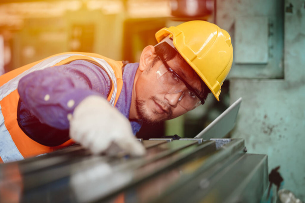 Asiatische Ingenieur Arbeiter beabsichtigt, professionell in der Stahlindustrie arbeiten, hohe Präzision Detailarbeit. - Foto, Bild