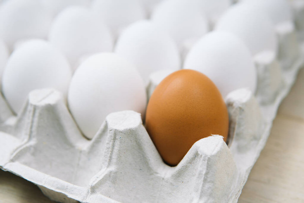Huevos frescos de pollo blanco y huevo solo marrón. Huevo orgánico natural con vista lateral. Comida sana y real - Foto, imagen