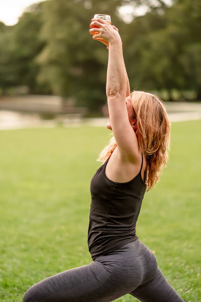 femme faisant du yoga tenant un verre de bière yoga bière ou concept de yoga ivre - Photo, image