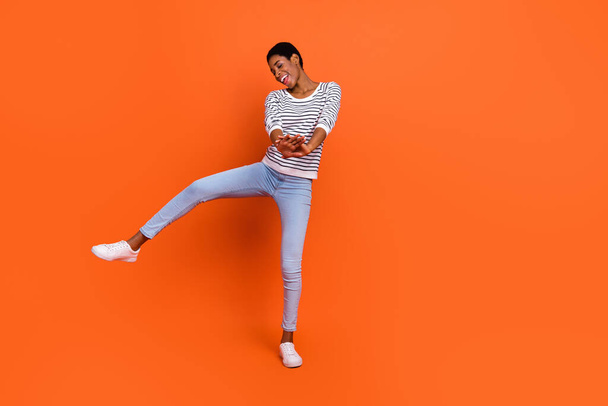Photo of funky pretty butch lady dressed sweater rising dancing smiling isolated orange color background - Foto, imagen
