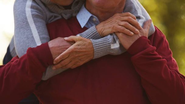 高齢者白人結婚カップル抱擁と保持彼らの手フォーカス上の手目に見える選択的フォーカスを閉じる - 写真・画像