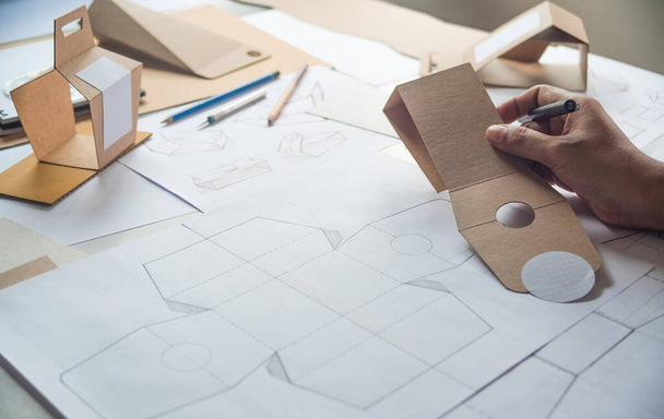 Designer sketching drawing design Brown craft cardboard paper product eco packaging mockup box development template package branding Label . designer studio concept . - Fotoğraf, Görsel