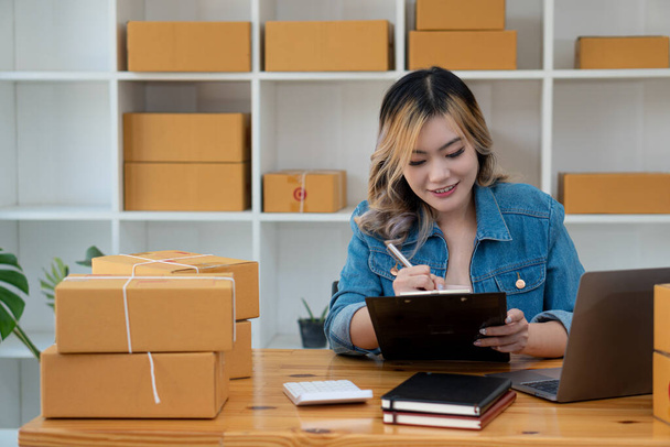 Young Business Owners Work from Home Online Business Ideas Startup Small Business SME uses laptops to receive and check orders to prepare boxes for shipping products. Sales - Photo, Image