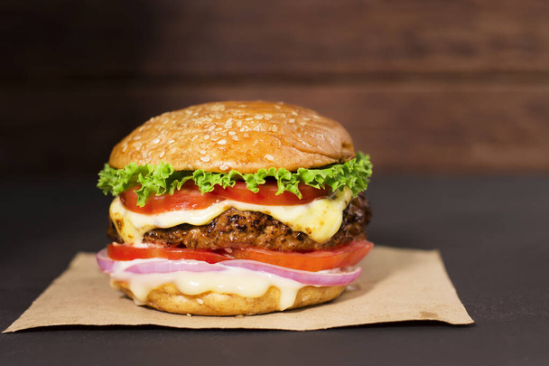 Close-up of delicious homemade burgers on a wooden table on a dark background beef hamburger freshly cooked delicious - Foto, immagini