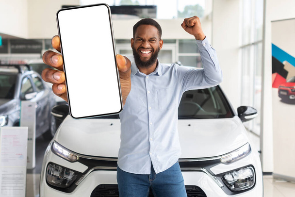 Online Tarjous. Innoissaan musta mies tyhjä älypuhelin seisoo auton näyttelytila - Valokuva, kuva