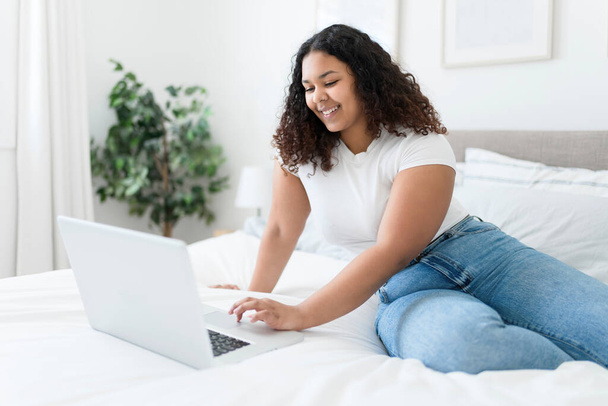 girl using laptop in bed during morning time at home - Foto, Imagen
