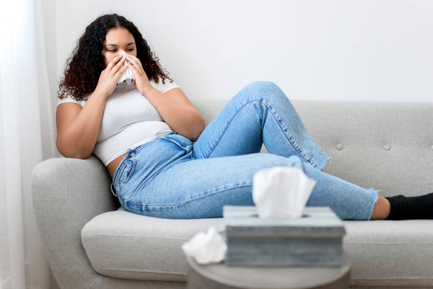 Sick ill black woman with tissue sitting on sofa - Φωτογραφία, εικόνα