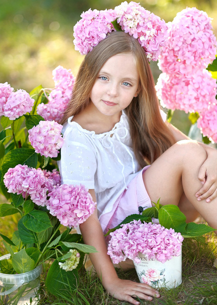 portrait of little girl with flowers hydrangea - Foto, afbeelding