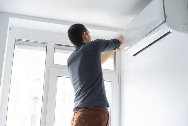 屋内で現代のエアコンを維持する専門の技術者 - 写真・画像