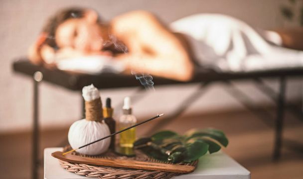 Happiness on a woman's face after a relaxing Thai massage. a table with incense in front of a girl on massage. - Photo, Image