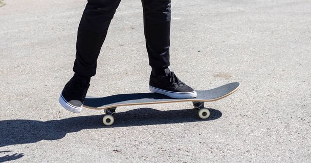 Close-up de umas pernas em um skate  - Foto, Imagem