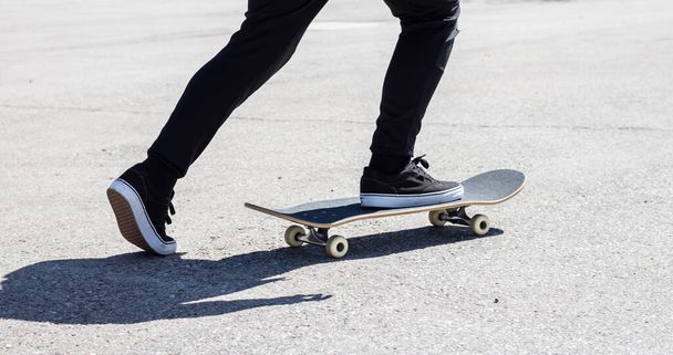 Close-up de pernas que impulsionam um skate - Foto, Imagem
