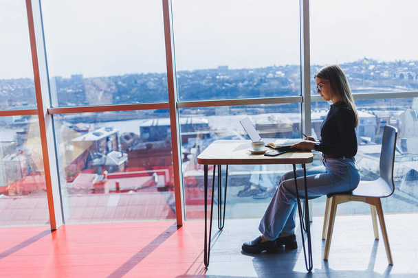 Mulher europeia feliz trabalhando online na cafetaria usando laptop e espaço de cópia de café. Freelancer feminino bem sucedido digitando no laptop, trabalho remoto - Foto, Imagem