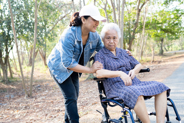 Aziatische senior of oudere oude dame patiënt op rolstoel in het park, gezonde sterke medische concept - Foto, afbeelding