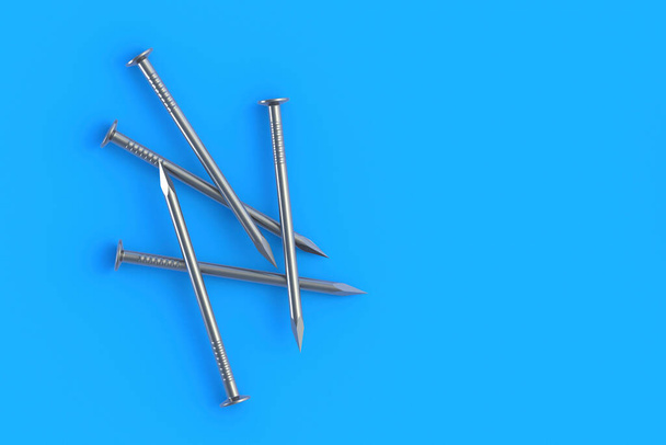 Metal nails on blue background. Building equipment. Tool for repair, renovation. Top view. Copy space. 3d render - Zdjęcie, obraz