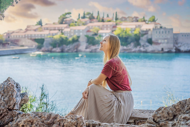 Woman tourist on background of beautiful view of the island of St. Stephen, Sveti Stefan on the Budva Riviera, Budva, Montenegro. Travel to Montenegro concept - Photo, Image