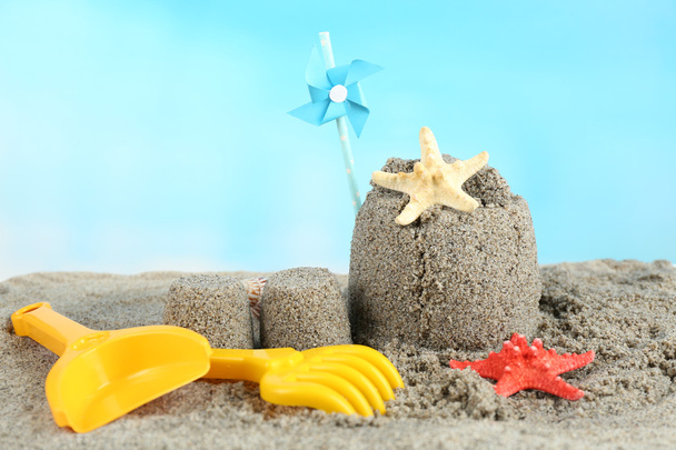 Sandcastle με pinwheel σε αμμώδη παραλία  - Φωτογραφία, εικόνα