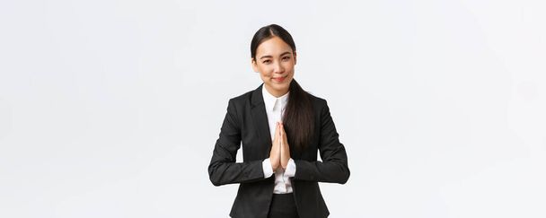Dost canlısı Asyalı iş kadını el ele tutuşup iş ortaklarına selam veriyor, müşterileri selamlıyor. Kadın girişimci namaste ve hoş geldiniz diyor, beyaz arkaplan - Fotoğraf, Görsel