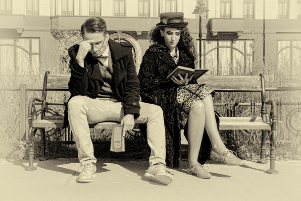 Jovem casal em briga sentado no banco na cidade velha
 - Foto, Imagem