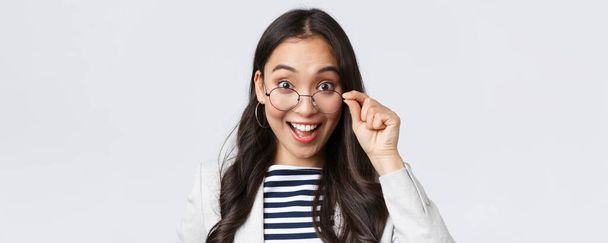 Business, finance and employment, female successful entrepreneurs concept. Excited happy asian office worker take-off glasses and smiling astonished as receive awesome deal - Foto, Imagen