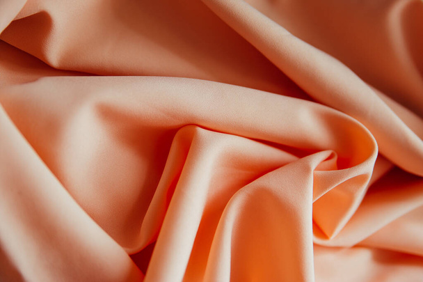 El tejido beige arrugado se encuentra en pliegues y cortinas. Textil textura en color rosa - Foto, Imagen