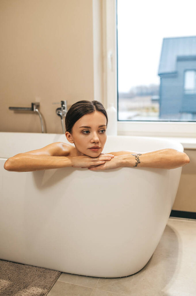 Low-spirited thoughtful woman sitting in the bath - Foto, Imagen