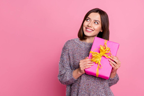 Photo of dreamy pretty woman wear pullover yellow holding gift looking empty space isolated pink color background - Foto, immagini