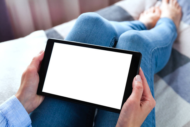 Woman holding digital tablet with blank white desktop screen sitting on the bed. Tablet blank screen mockup. Close-up. Copy space. - Photo, Image