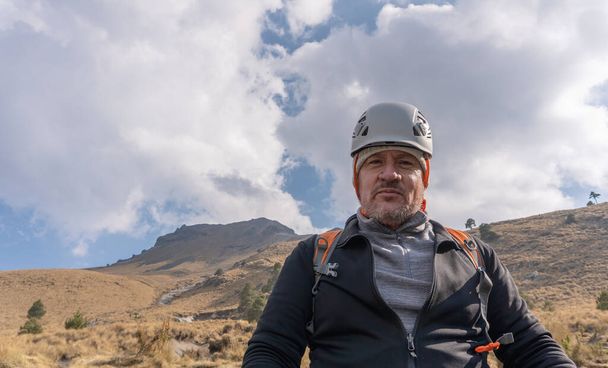 Портрет взрослого туриста, улыбающегося в горах - Фото, изображение