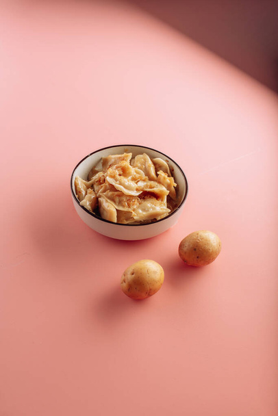 dumplings in a plate on a pink background. High quality photo - Φωτογραφία, εικόνα
