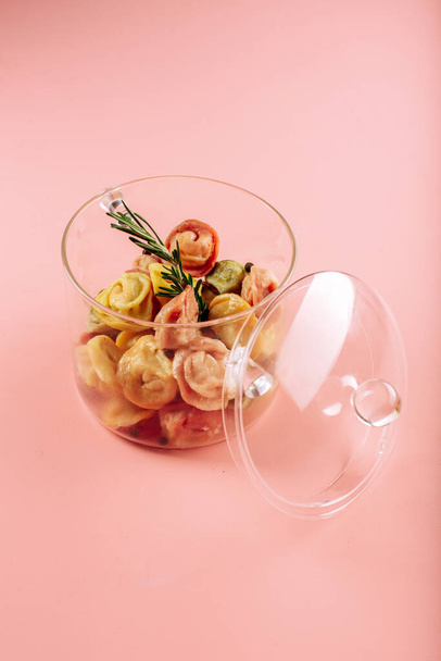 dumplings in a transparent saucepan on a pink background. High quality photo - Fotó, kép