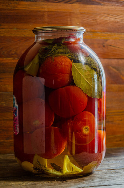 Маринованные помидоры в трехлитровой банке. Домашние продукты и огурцы. - Фото, изображение