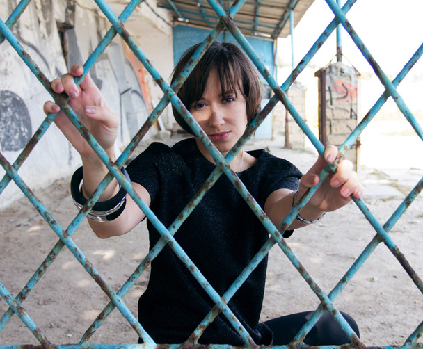 ein Mädchen hinter den blauen, verrosteten Gittern - Foto, Bild