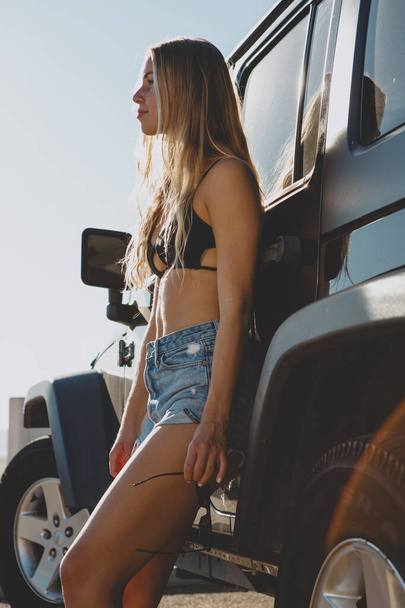 surfer girl sitting at a car in Malibu. On film California - Zdjęcie, obraz