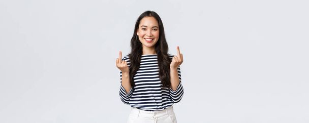 Lifestyle, beauty and fashion, people emotions concept. Unbothered and careless young happy smiling woman dont give a damn, showing middle fingers and feeling good, white background - Foto, Bild