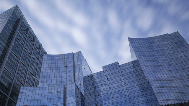 Rascacielos de cristal azul con nubes pasando
 - Metraje, vídeo