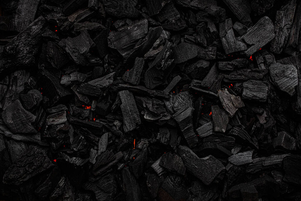 Charcoal with red streaks of heat. Textured dark background. - Photo, Image