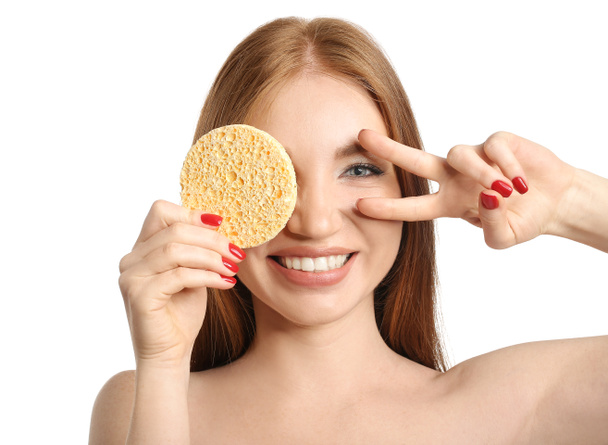 Happy woman with makeup sponge showing victory gesture on white background - Photo, Image