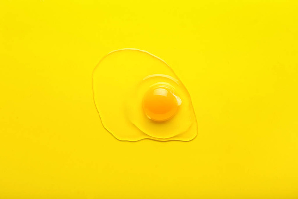 Fresh raw chicken egg on yellow background - 写真・画像